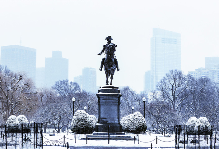 Statue of man riding a horse covered in snow