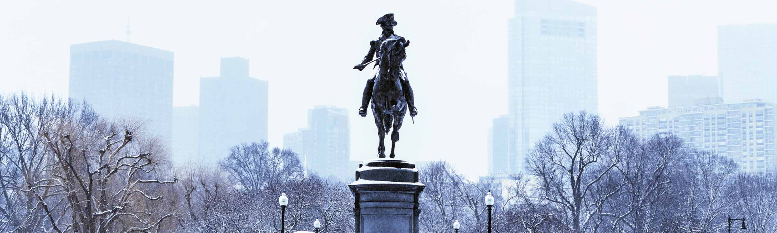 Statue of man riding a horse covered in snow